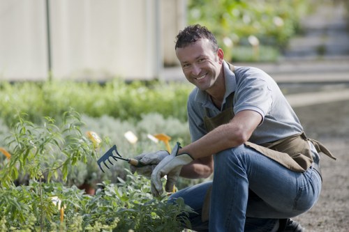 Close-up of a gardener tending raised beds in a Spitalfields garden demonstrating accessible design.